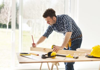 Focus man measuring wooden planks